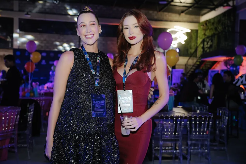 Duas convidadas elegantes no salão do MOVE Anos 2000