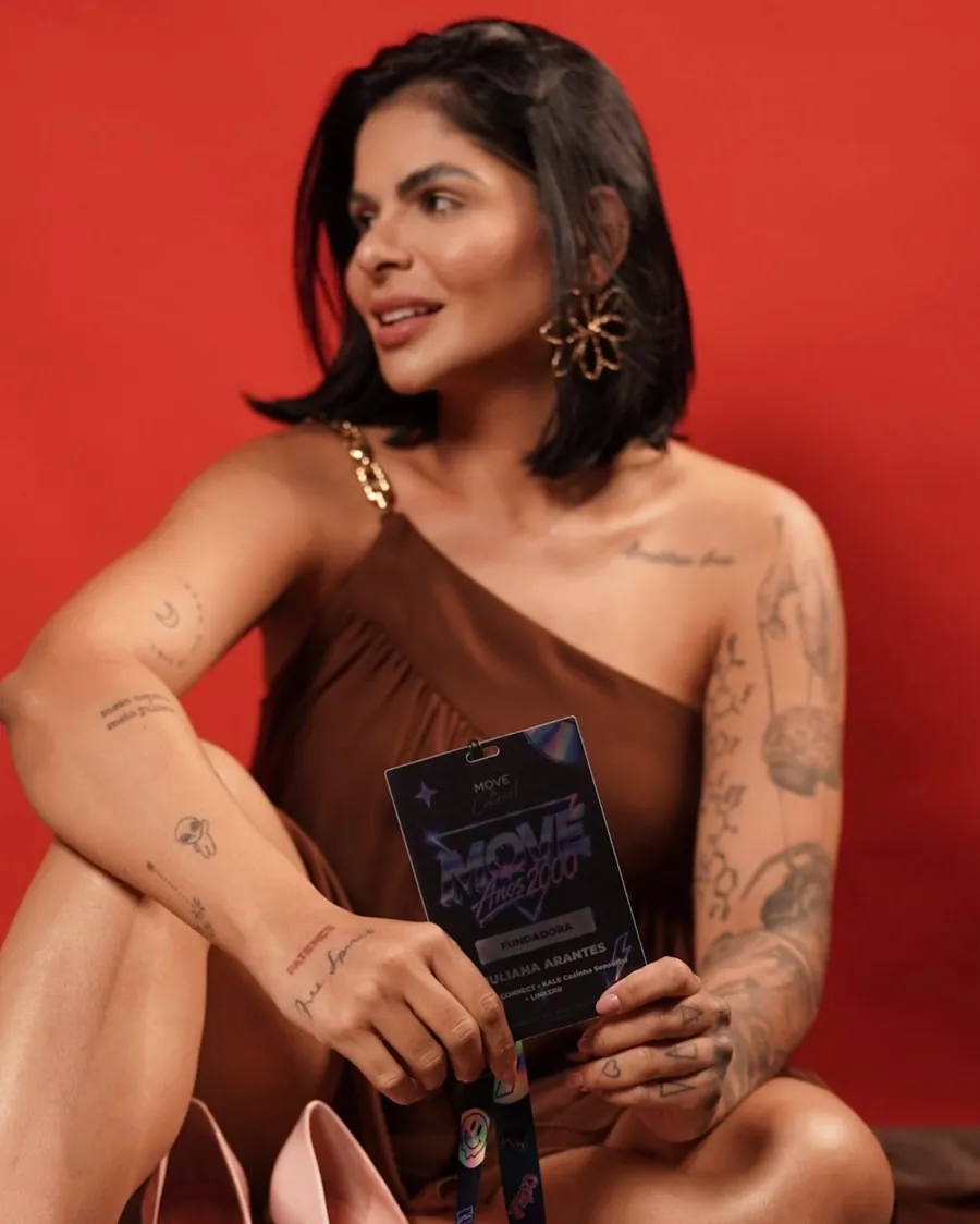 Juliana Arantes, fundadora do MOOVE, em foto de estúdio segurando o crachá de fundadora